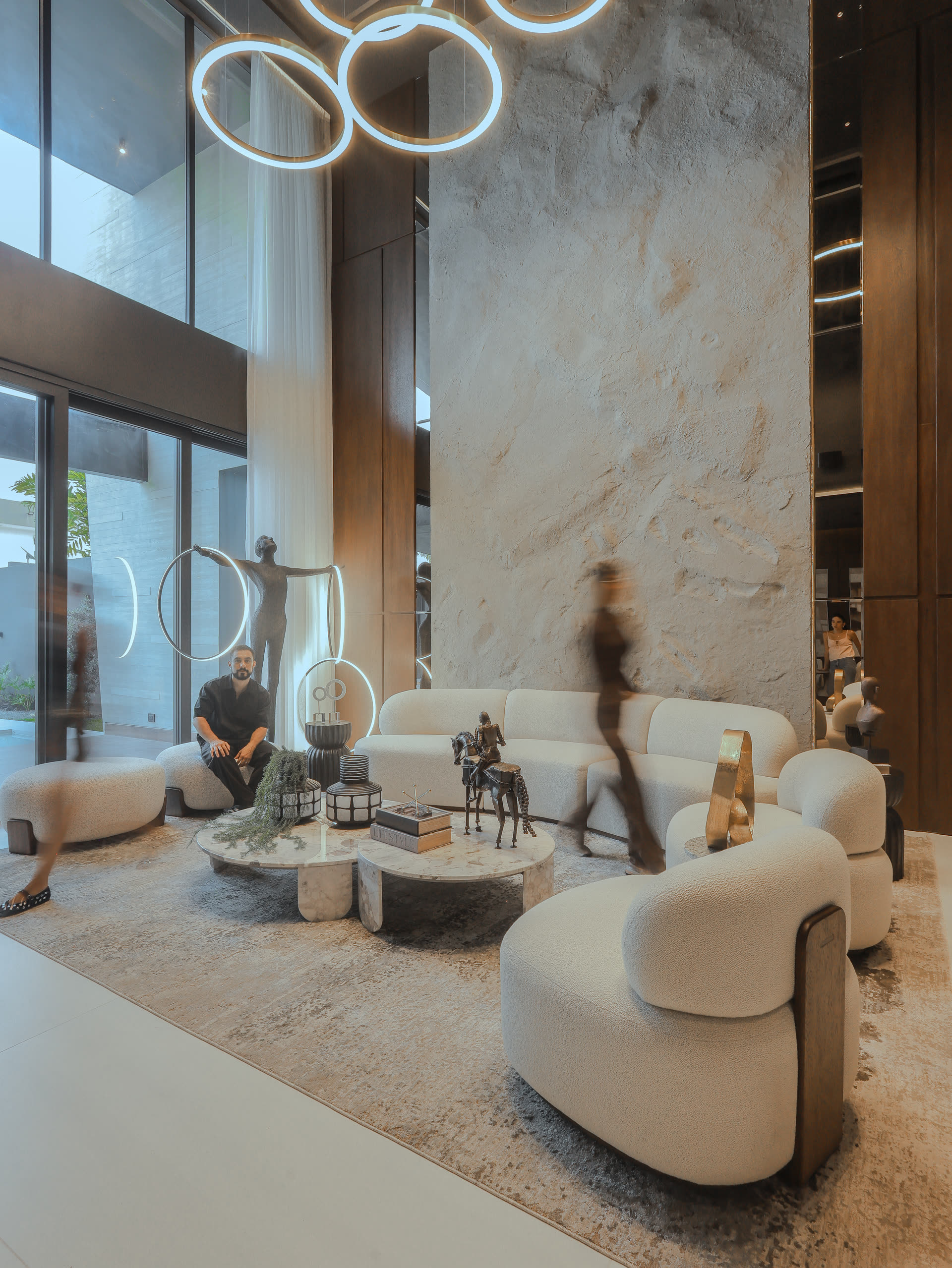 Estar de Casa Cueva construida, con mobiliario curvo y muro de piedra