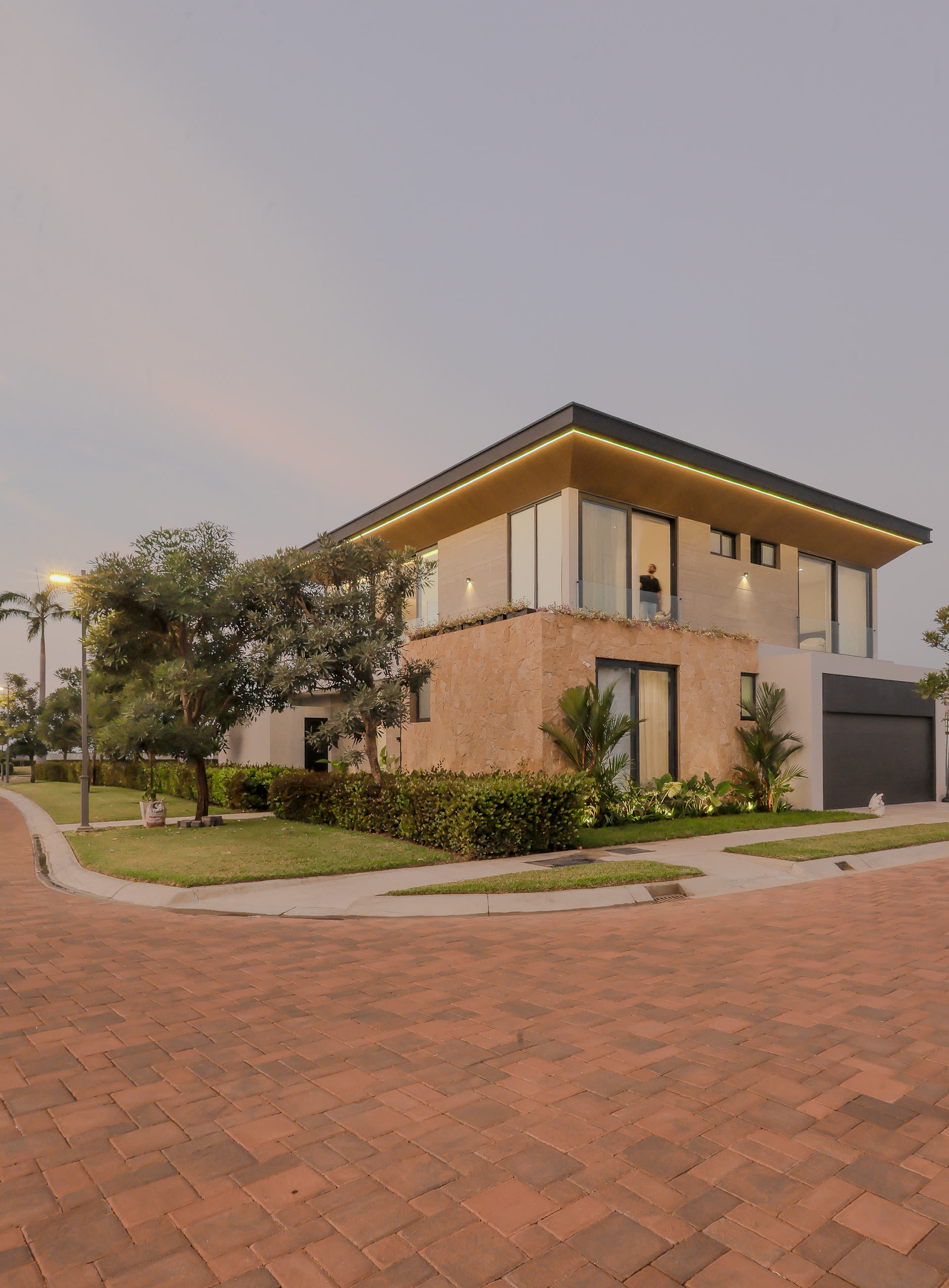 Vista de esquina de Casa MM con jardinería y acera