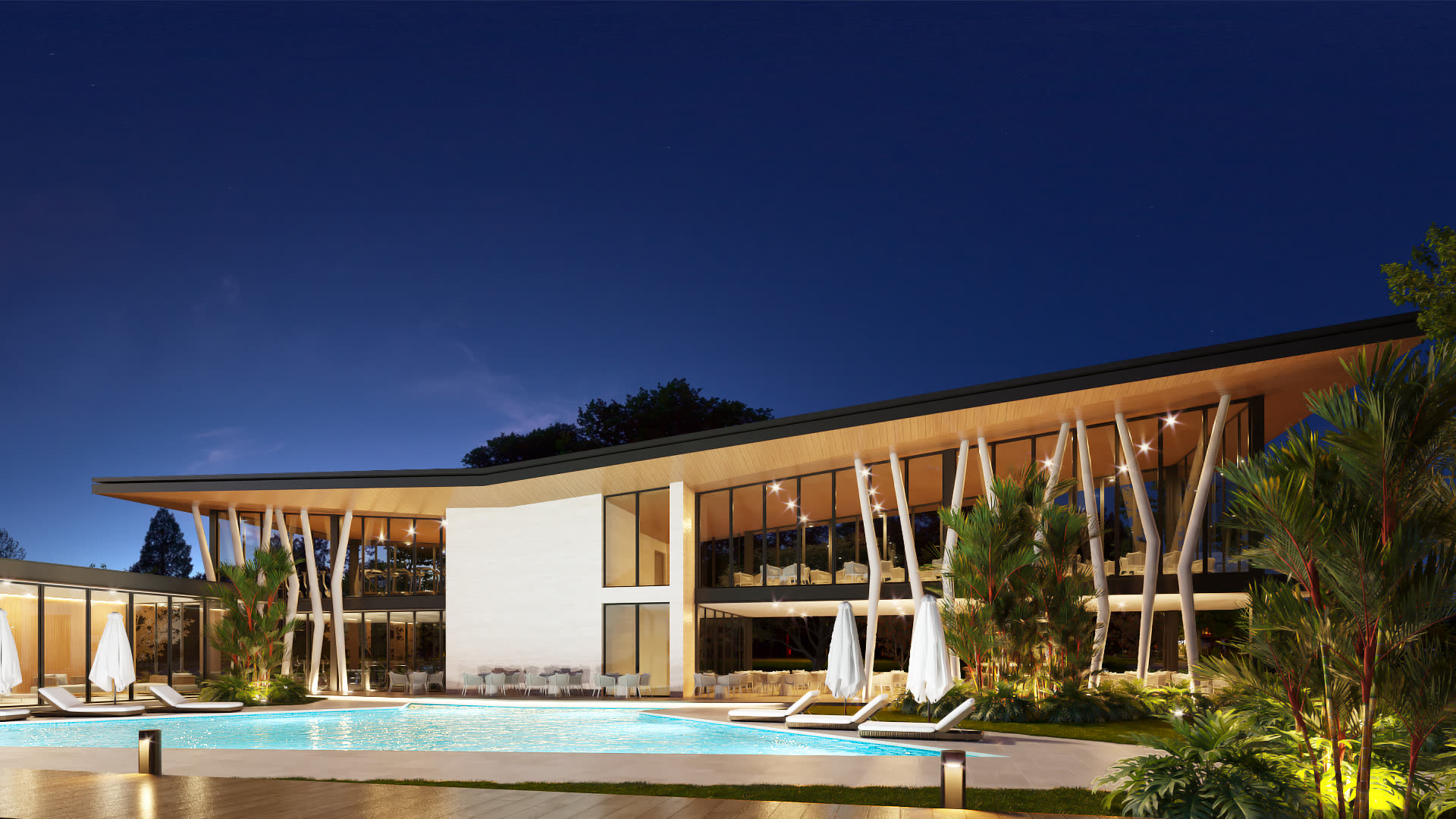 Casa club de Moriáh al anochecer, con cubierta a dos aguas y piscina