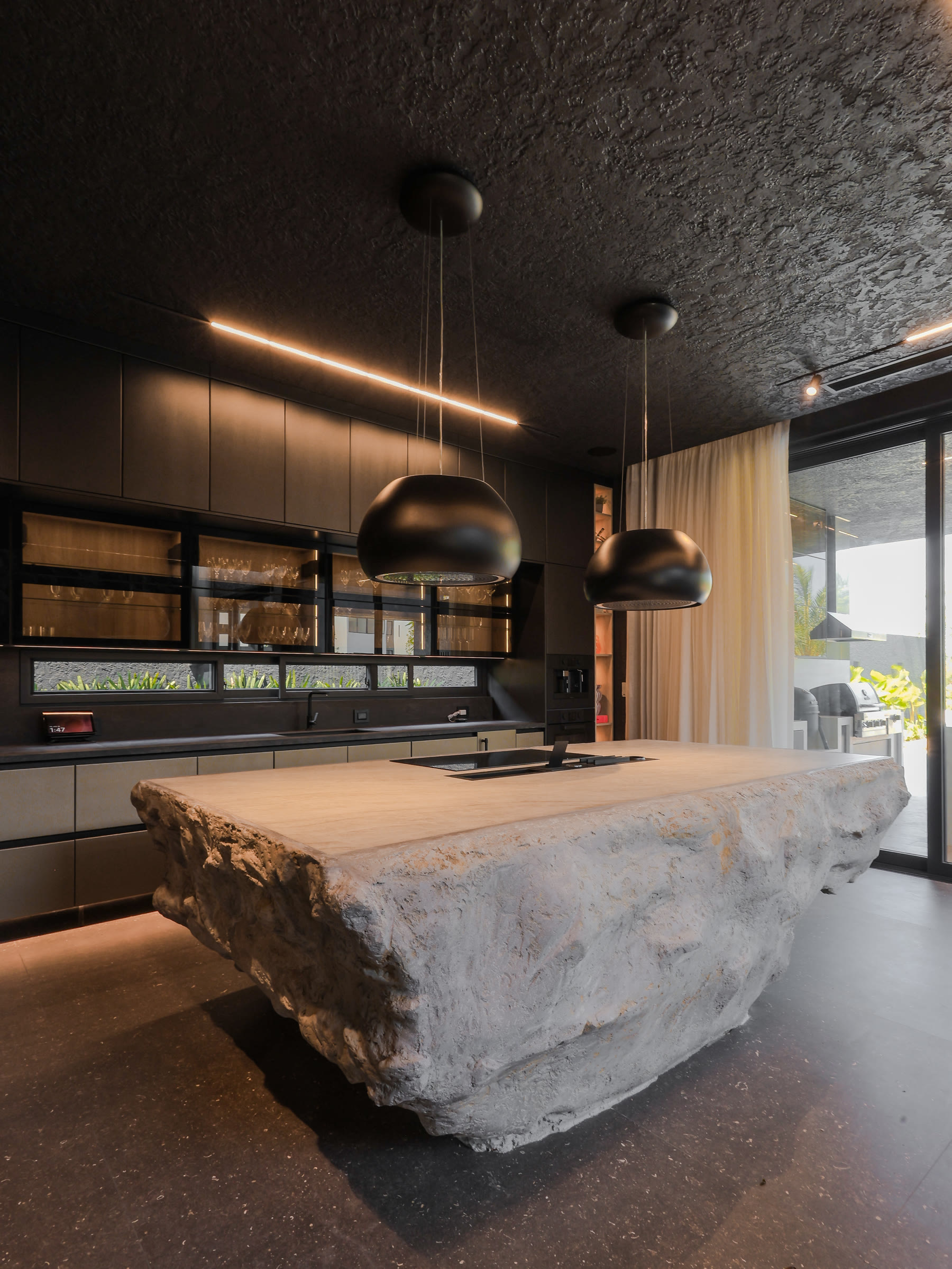 Cocina de Casa H1 con isla monolítica de piedra en bruto