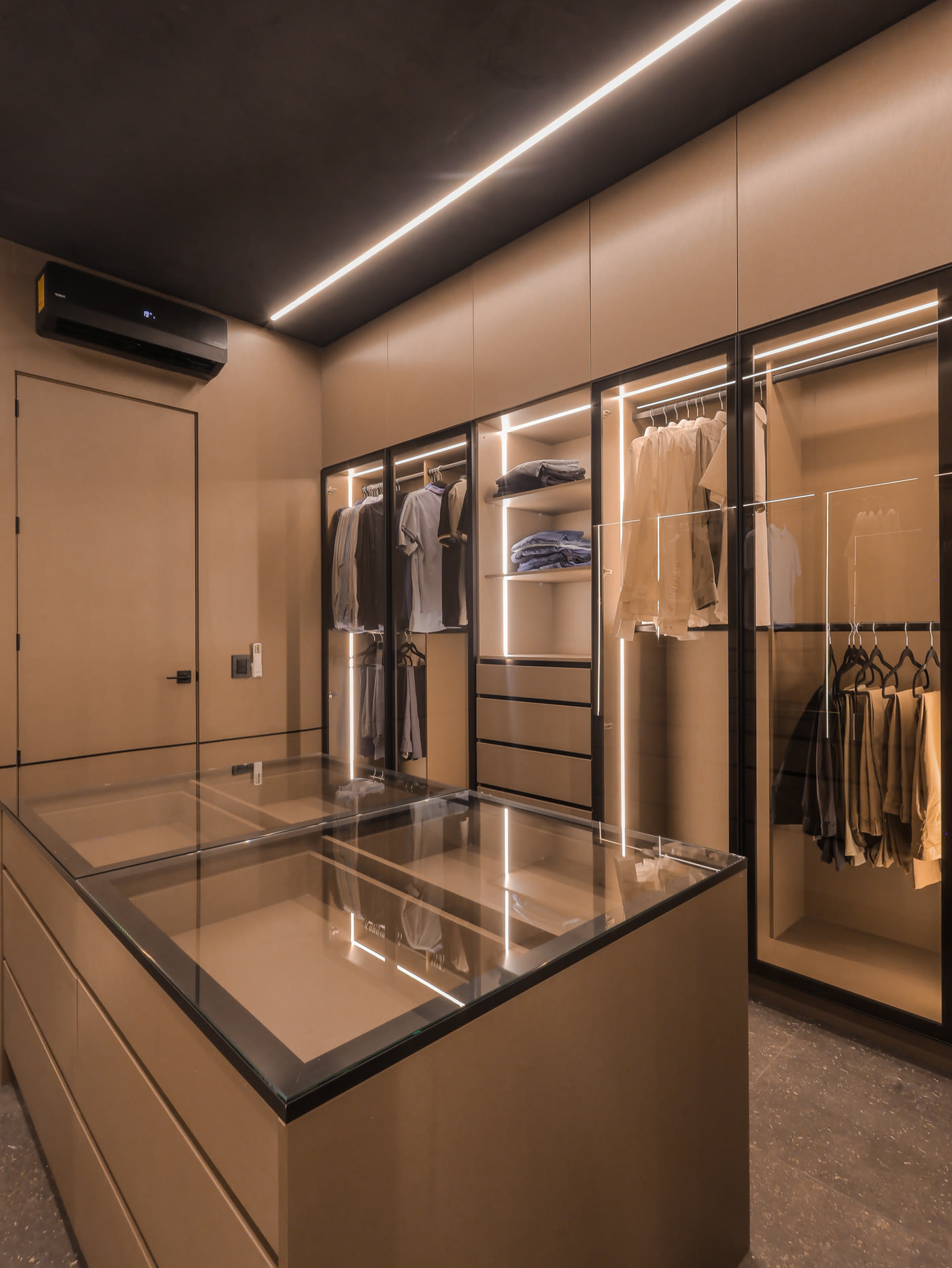 Vestidor de Casa H1 con vitrinas iluminadas