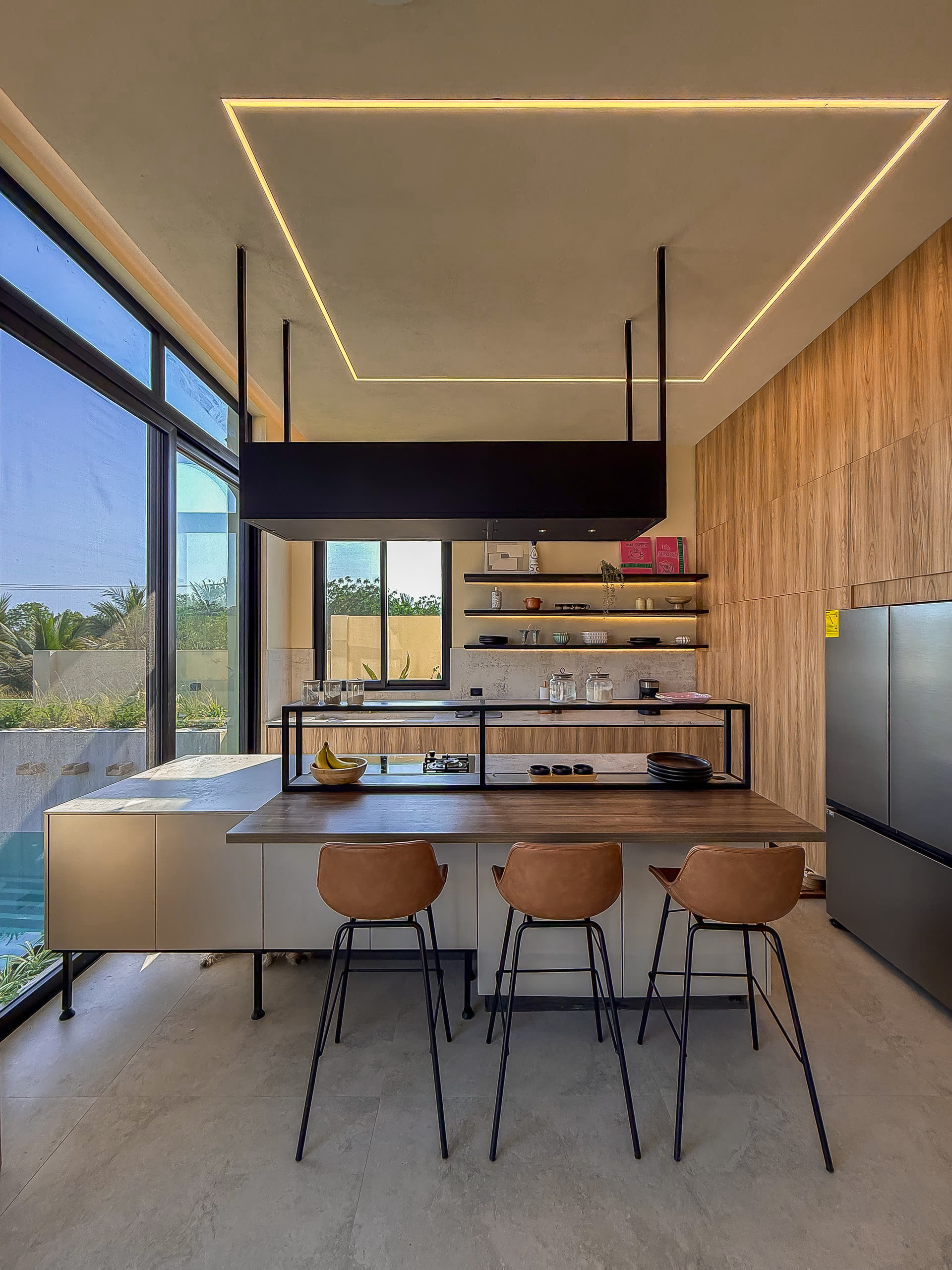 Cocina con isla, barra de madera y estantería abierta