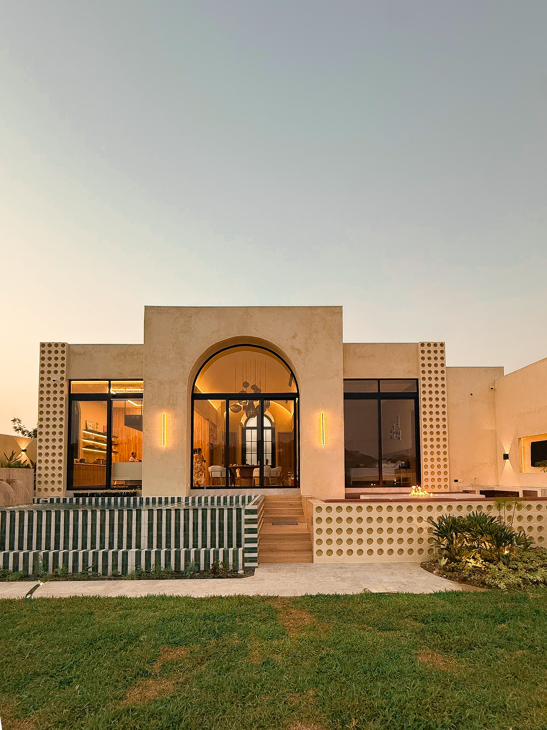 Fachada de la Casa 03 en Sol de Olón, con arco de ingreso y celosía de ladrillo