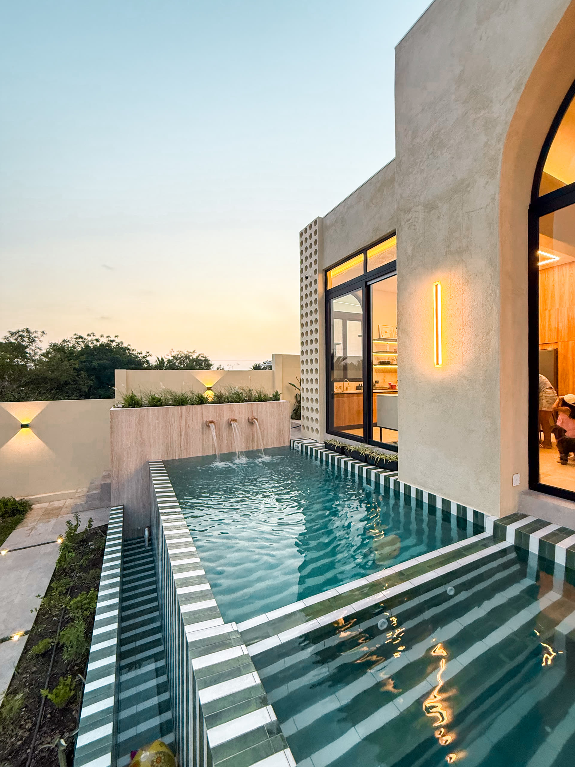 Piscina de la casa con revestimiento verde y celosía de ladrillo