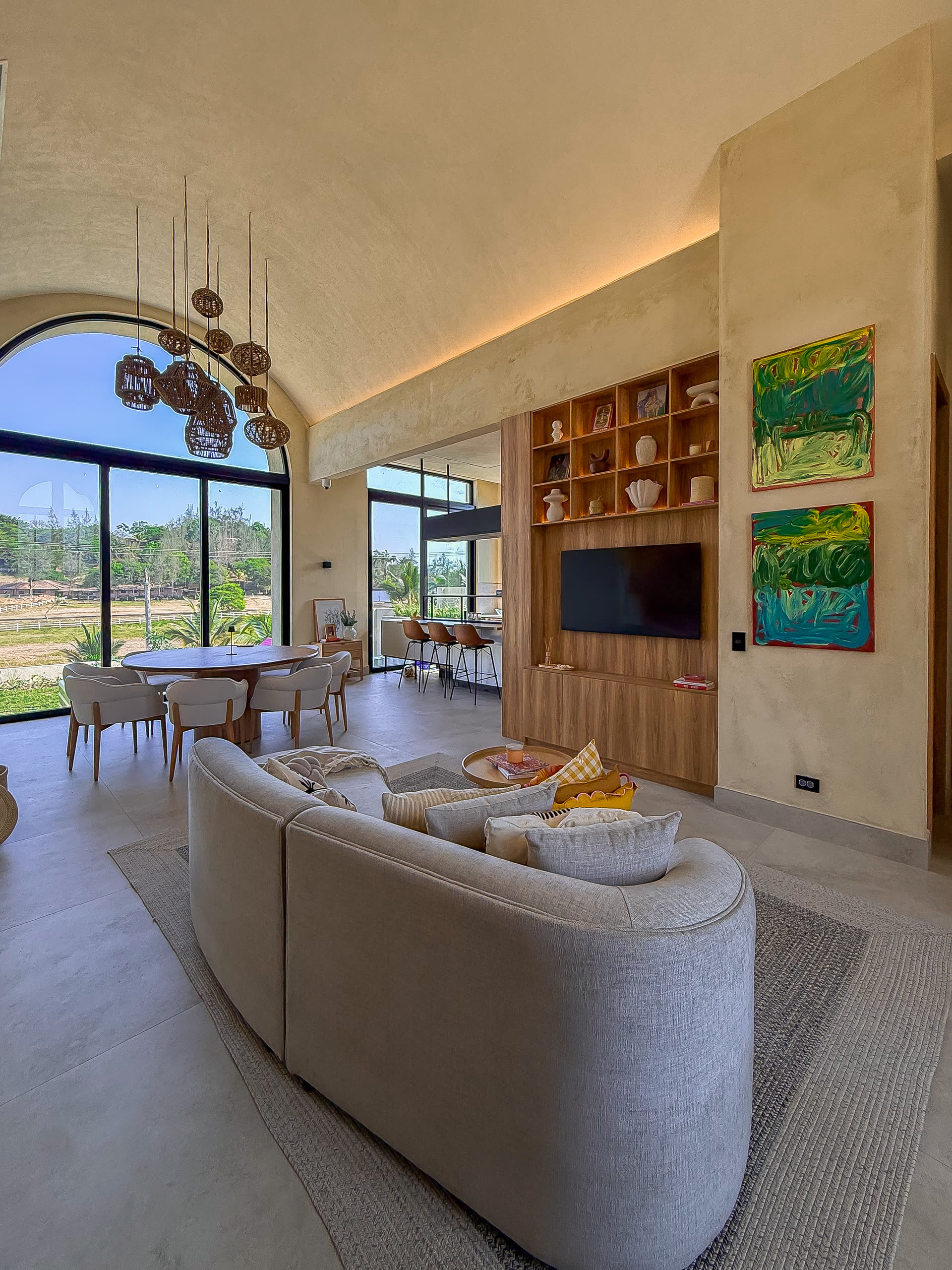Sala de la casa con sofá curvo y ventanales al paisaje