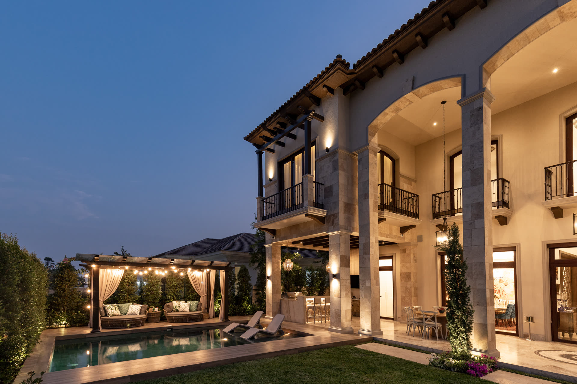 Terraza cubierta junto a la piscina, con pérgola y comedor exterior